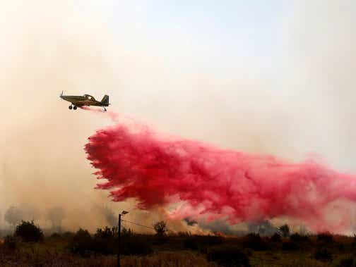 A firefighting aircraft releases flame retardant to extinguish fires caused by rockets launched from southern Lebanon which landed on the outskirts of Safed, in the upper Galilee, on Wednesday.