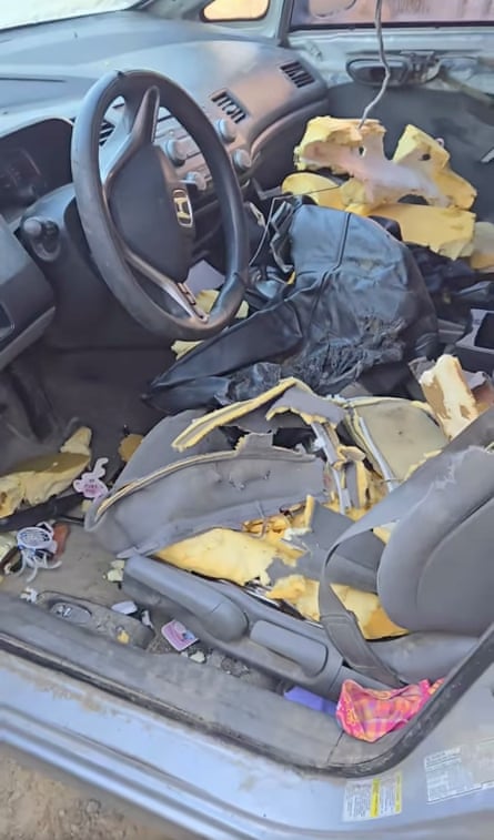 the front seats of a car are shredded with debris strewn around