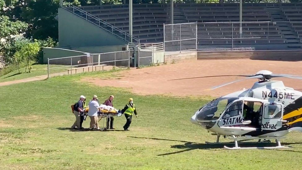 Salman Rushdie being moved to a helicopter