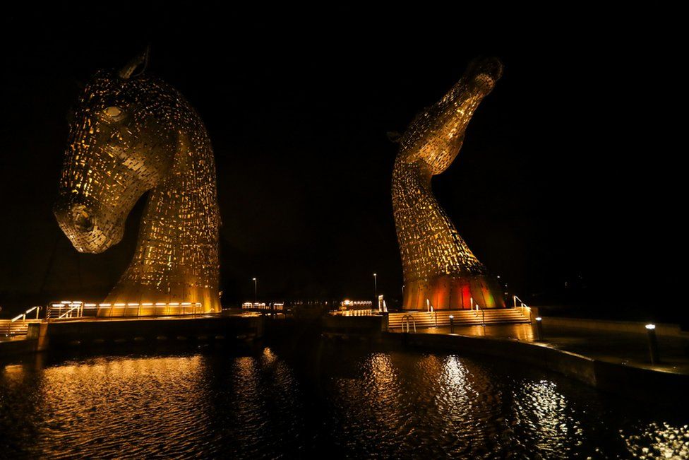 The Kelpies sculpture is illuminated in yellow, as part of a day of reflection to mark the anniversary of Britains first coronavirus disease (COVID-19) lockdown, in Falkirk, Scotland, Britain March 23, 2021.