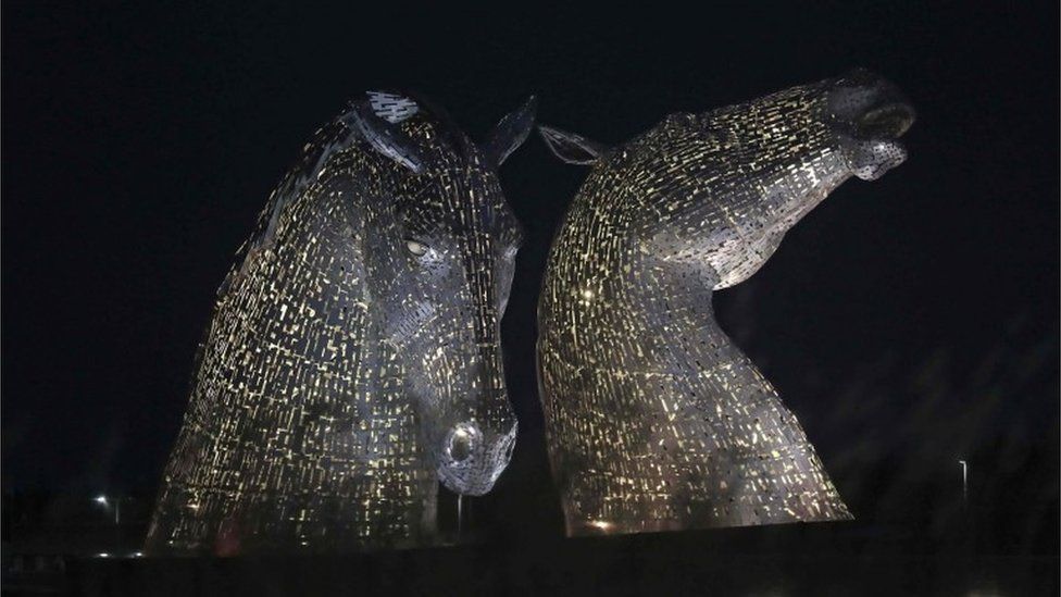 The Kelpies in Falkirk, Central Scotland, as they are lit up yellow